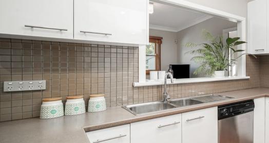 Glossy brown square tiles create a sleek splashback in this Parramatta kitchen