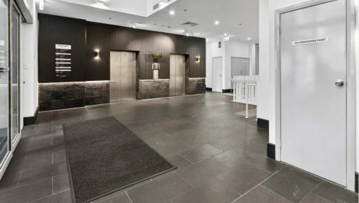 This Surry Hills lobby features large, dark slate floor tiles laid in a staggered pattern