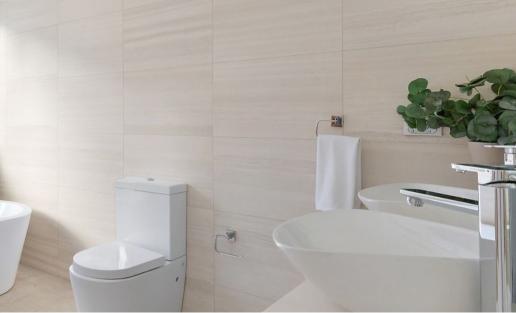 The bathroom in the Pymble home, has large, light-colored rectangular tiles arranged horizontally for a sleek and modern look