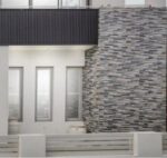 Textured grey stone cladding enhances the modern exterior of this home in Randwick