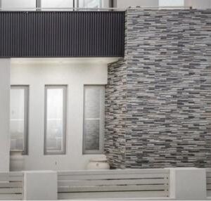 Textured grey stone cladding enhances the modern exterior of this home in Randwick