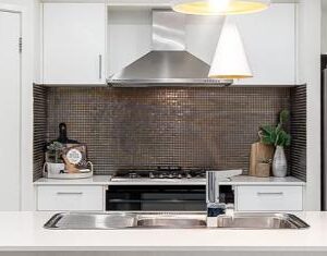 Glossy mosaic tiles in this kitchen, reminiscent of interiors found in Balmain, provide a striking backdrop